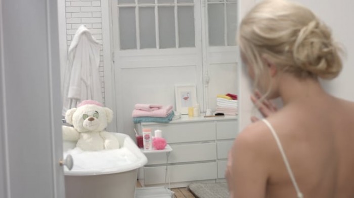 Cadum bear in the bath, mirroring the mother's ritual